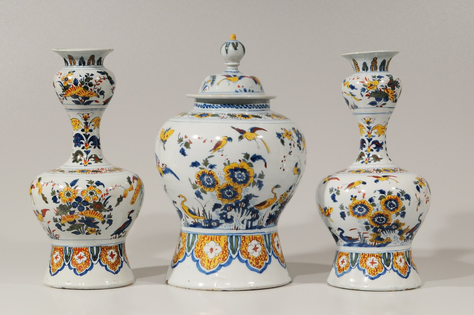 Garniture of antique ceramic pottery vases with one cover