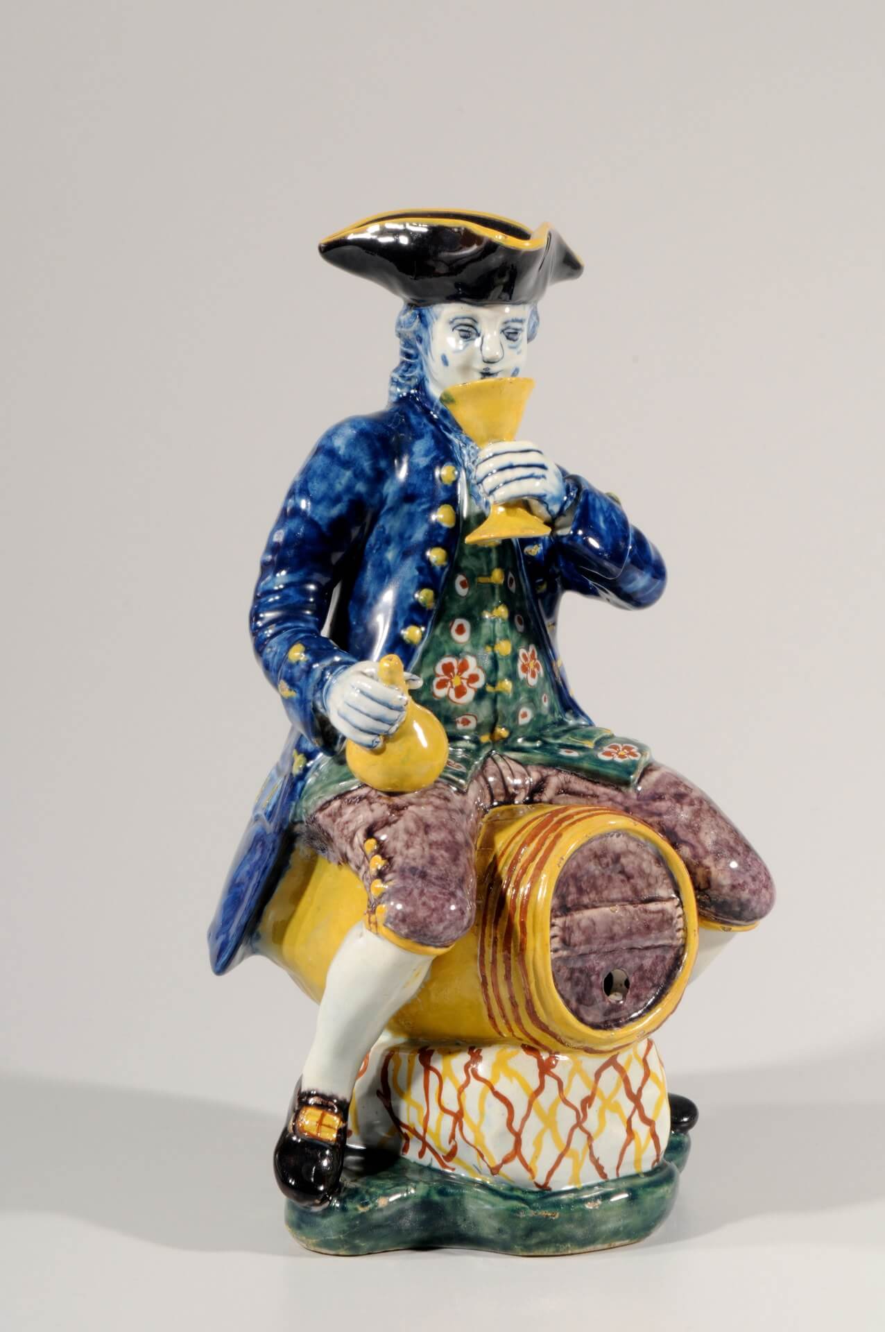 Antique Dutch Delft Pottery of man sitting on barrel in polychrome colours