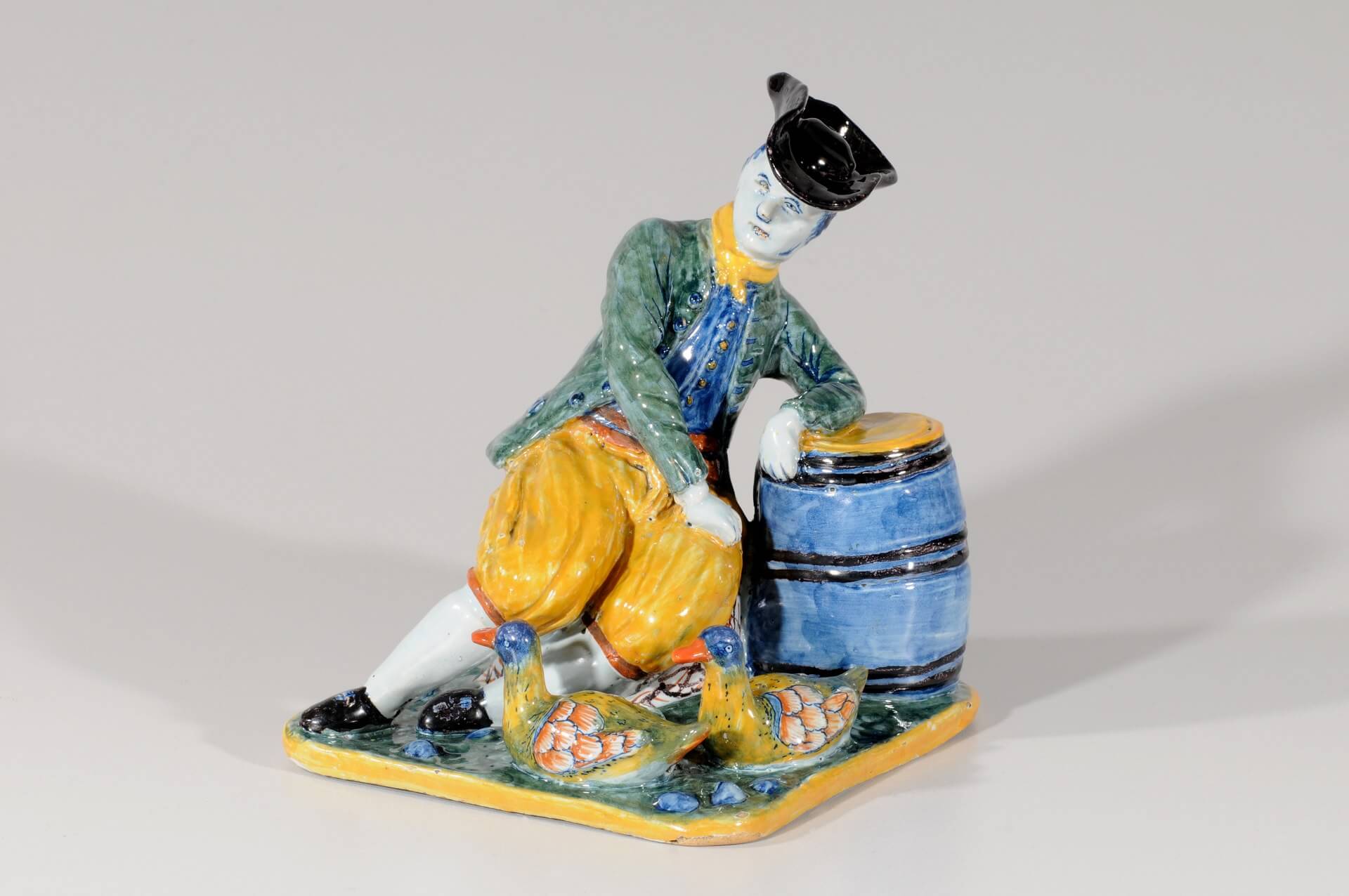 Antique polychrome figurine of man hanging on barrel