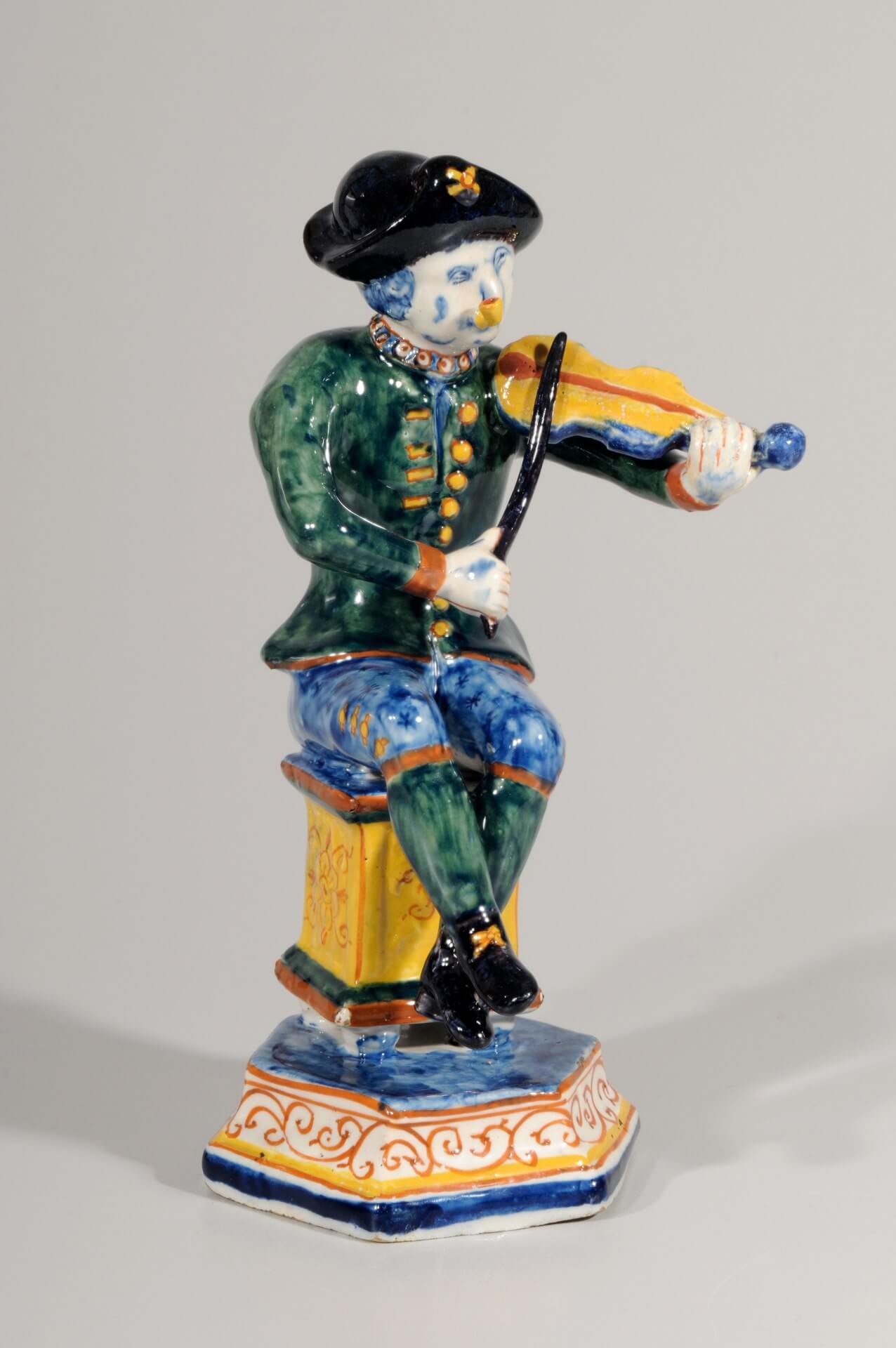 Ceramic Delft pottery figurine of man playing violin in polychrome colours