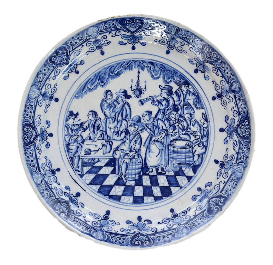 Antique blue and white plate pictured scene of merrymaking in a tavern