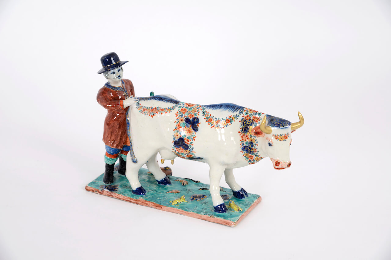 1924. Polychrome Petit Feu and Gilded Group of a Cow and Cowherd