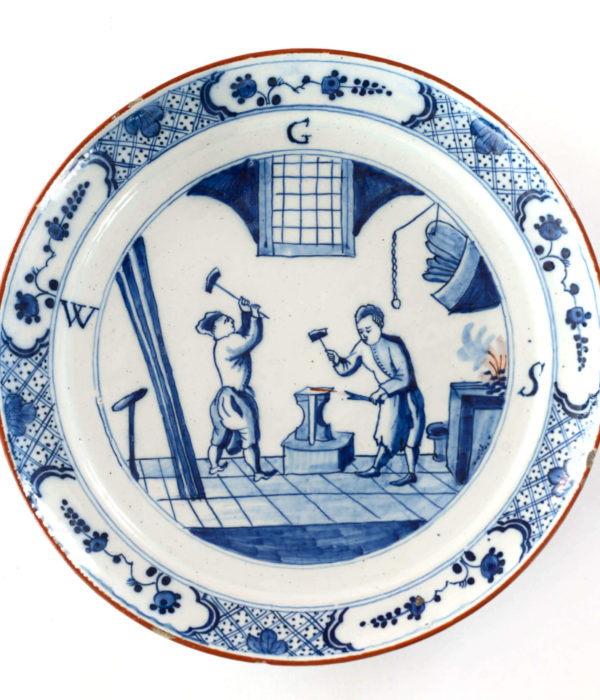 2069 Blue and white Delftware plate men in smithy