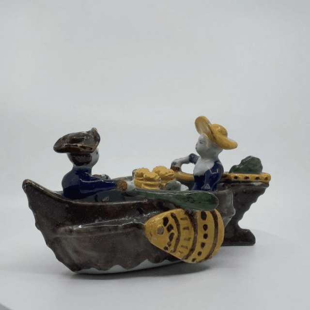 Polychrome group of couple in boat Polychrome group of couple in boat