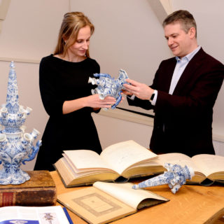 Céline and Robert studying a pair of 17th century Delftware tulipvases